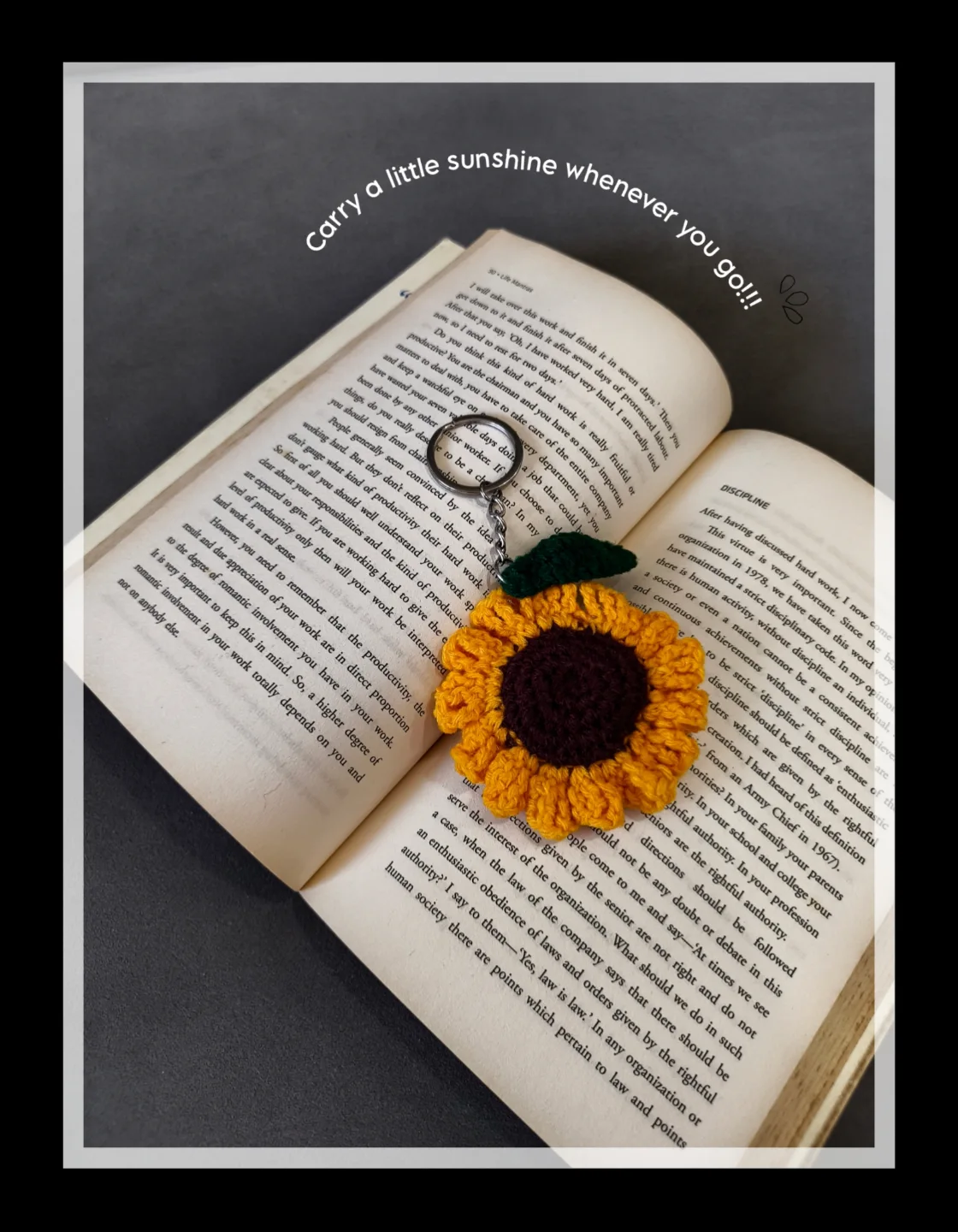 Sunflower crochet keychain on an open book.