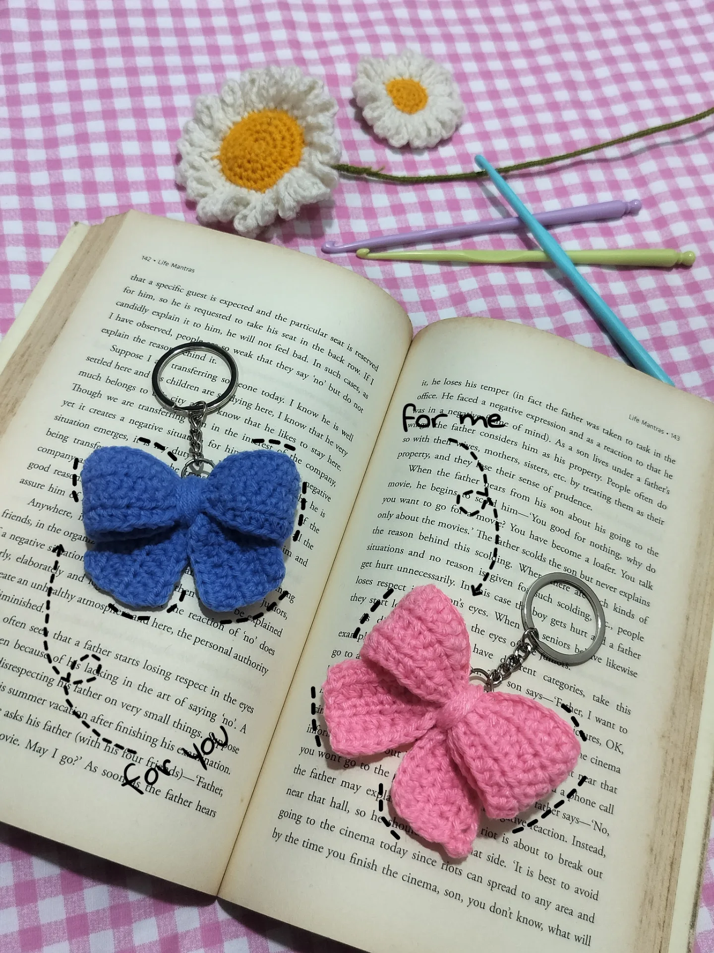 Pink and blue crochet bow keychains with daisies.