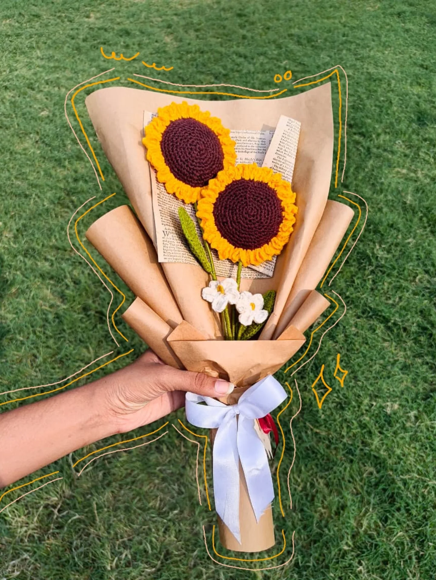Two sunflowers with daisies in a kraft-paper cone.